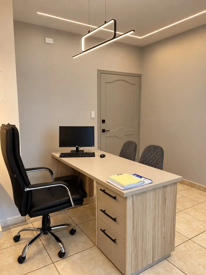 Otro consultorio de consulta externa, con su escritorio y un archivador.