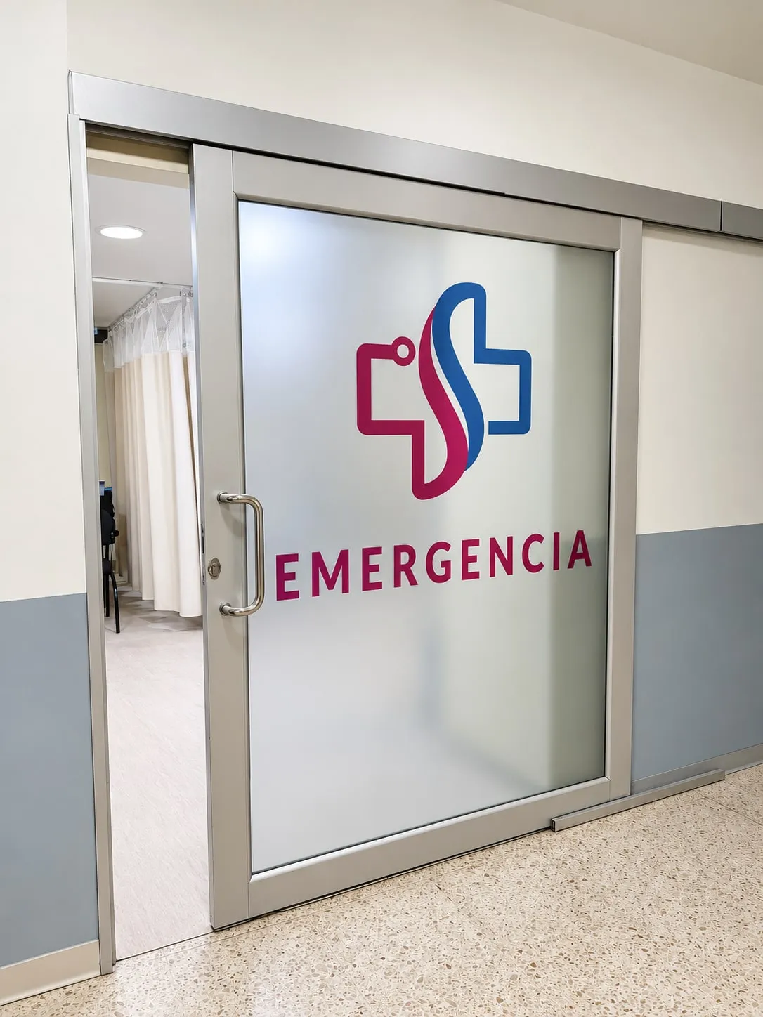 La puerta de vidrio del área de emergencia, con el logotipo del hospital.