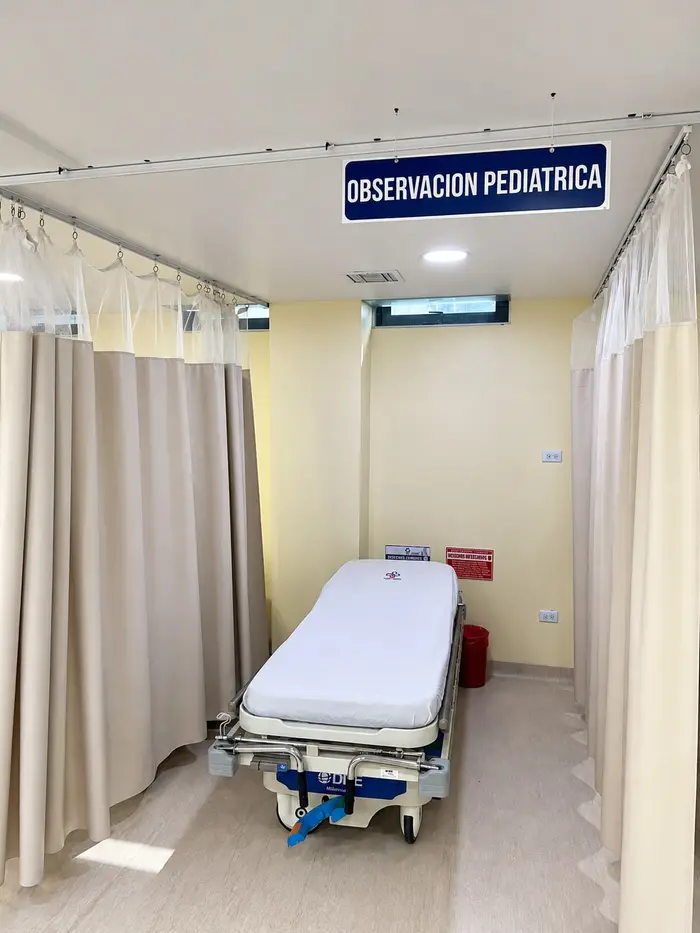 El área de observación pediátrica, con una camilla entre cortinas.