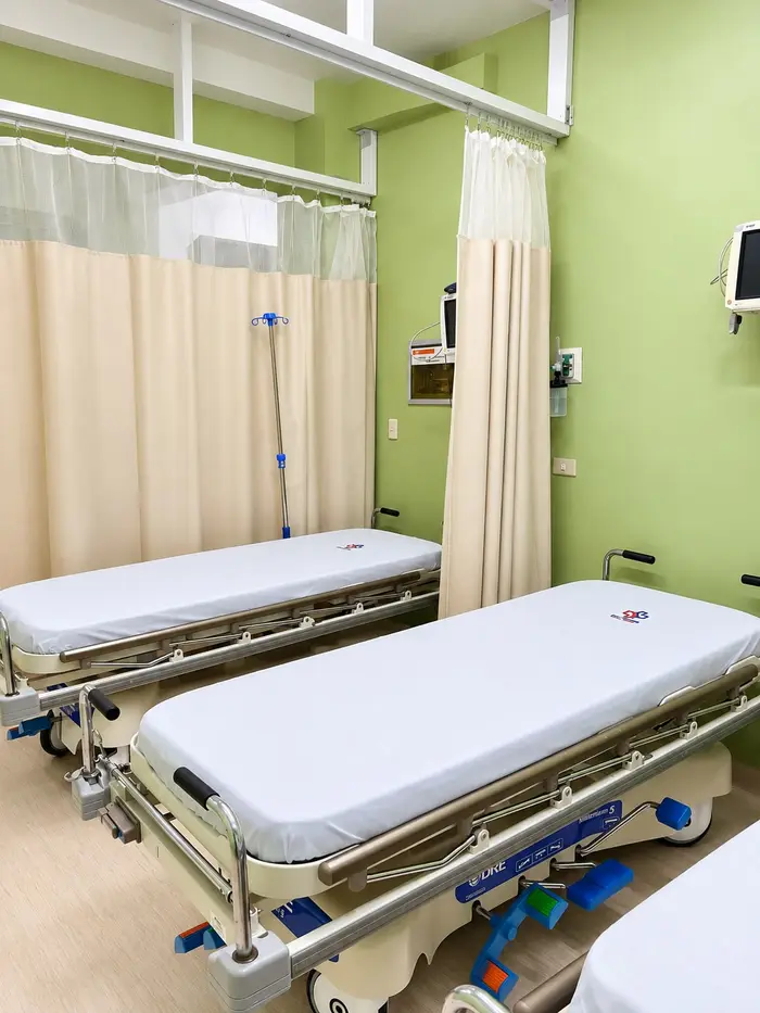 Vistazo a las camillas de la sala de recuperación, separadas por cortinas.