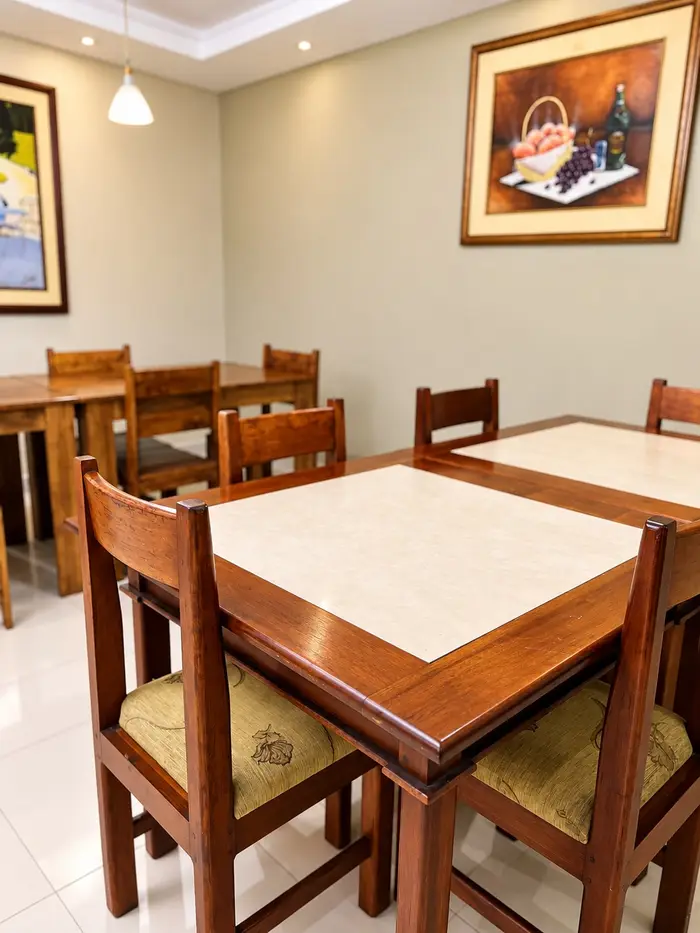 Una mesa del restaurante de cerca, con sus sillas tapizadas y cuadros en la pared.