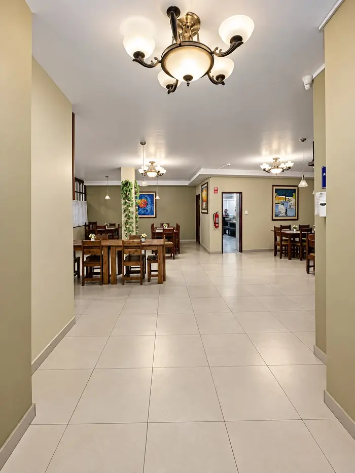 El pasillo del restaurante, con mesas a los lados y lámparas de araña.