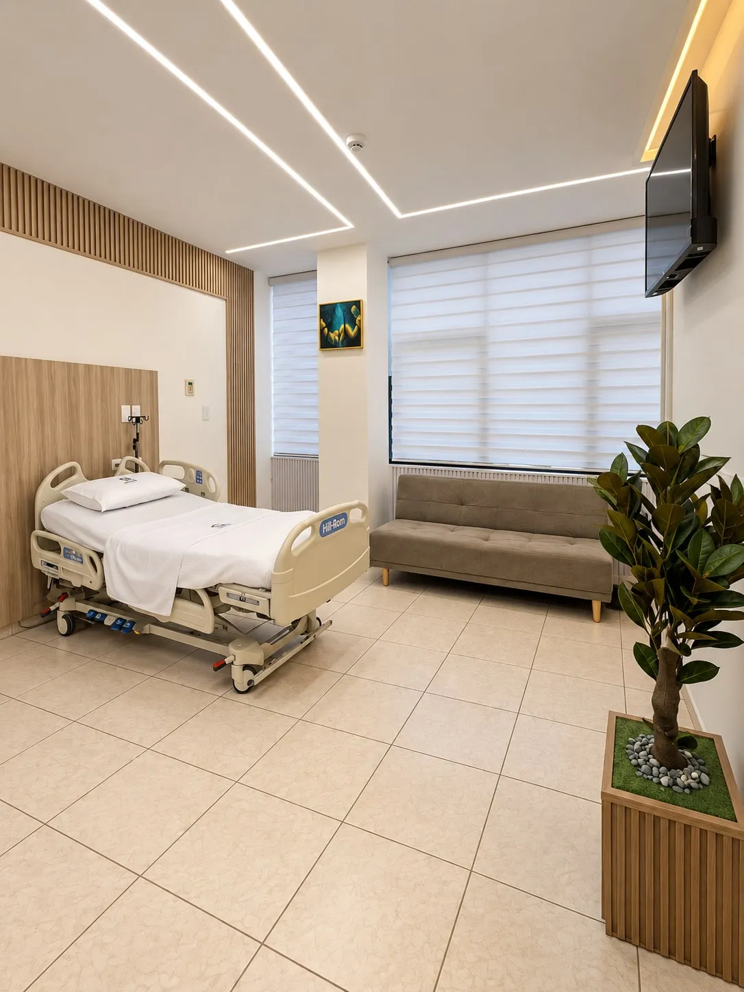 Una de las suites de hospitalización, con la cama y una sala junto a la ventana.