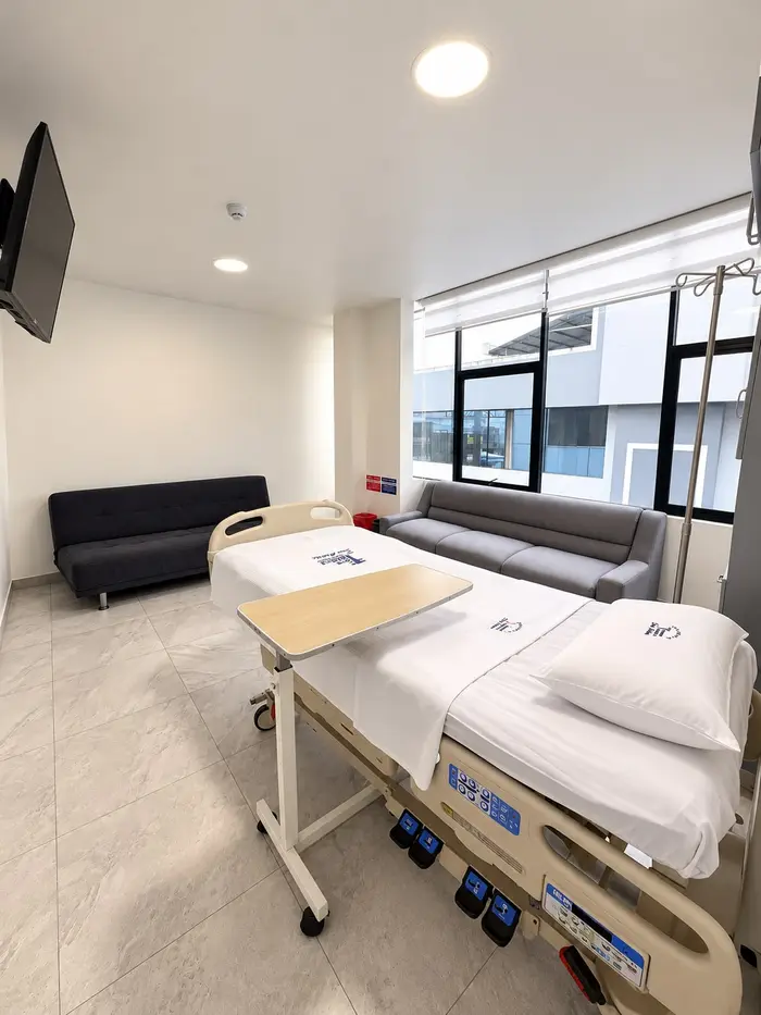 La tercera suite, con la cama, la mesa de comer y dos sofás junto a la ventana.